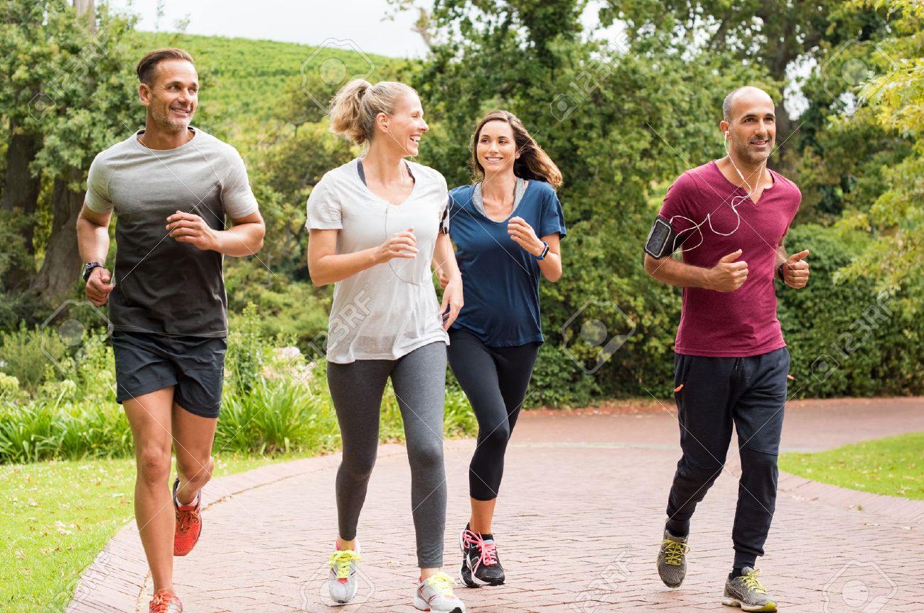 75431197 healthy group of people jogging on track in park happy couple enjoying friend time at jogging park w