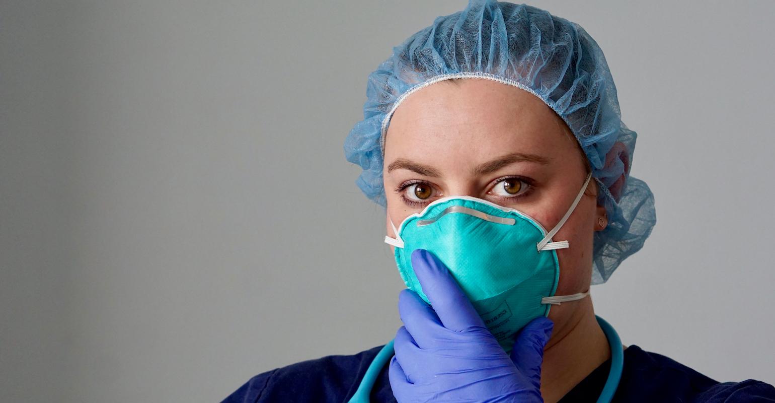 female nurse wearing green n95 mask